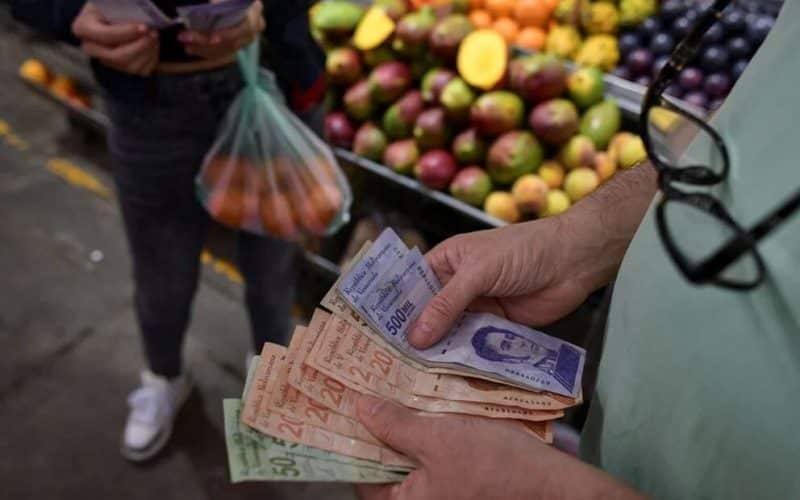 El consumo en Venezuela registró un incremento del 13% en el consumo durante el mes de abril de 2026 en comparación con el mismo período del año anterior, a pesar de haber enfrentado un aumento acumulado en los precios del 29%. Los datos fueron presentados por la firma especializada Atenas Grupo Consultor.  El director de la consultora, Alexander Cabrera, destacó que este comportamiento macroeconómico resulta completamente atípico al analizar el contexto de América Latina. Explicó que, bajo parámetros económicos tradicionales en la región, un alza de precios de esa magnitud suele traducirse de forma inmediata en una contracción severa de los volúmenes de venta y en una caída del consumo generalizado.  La nueva estructura del mercado: tres perfiles de consumo De acuerdo con el análisis de Atenas Grupo Consultor, el mercado venezolano no se comporta de manera homogénea, sino que se encuentra fragmentado y estructurado de forma interna en tres grandes bloques socioeconómicos diferenciados por su nivel de ingresos y hábitos de compra:  El segmento de altos ingresos (7% de los hogares): Este grupo cuenta con ingresos mensuales superiores a los 1.500 dólares. Su comportamiento se caracteriza por una nula sensibilidad ante el incremento de los precios en los anaqueles, orientando su gasto hacia la demanda de innovación, marcas exclusivas, variedad de categorías y productos de la gama premium.  El segmento intermedio (29% de los hogares): Dispone de un presupuesto familiar estimado en torno a los 800 dólares mensuales. Este perfil conforma un tipo de consumidor racional y analítico que compara precios de forma constante, evalúa el rendimiento real de los bienes antes de adquirirlos y ajusta de manera dinámica sus decisiones de compra. No obstante, conserva la capacidad financiera suficiente para sostener su volumen de consumo habitual dentro de su rango de marcas seleccionadas.  El segmento mayoritario (64% de los hogares): Corresponde a la base de la pirámide y prioriza de manera exclusiva el factor precio en su economía de subsistencia. Para adaptarse a sus limitaciones presupuestarias, este estrato de la población se ha desplazado masivamente hacia los formatos de empaque pequeños, las modalidades de compra fraccionada y un esquema de reposición de productos con periodicidad diaria.  Con información de Descifrado